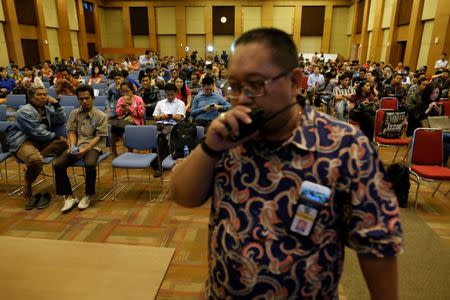 A tax officer stands as people wait for tax amnesty at the country's tax headquarters in Jakarta, Indonesia September 30, 2016. REUTERS/Beawiharta