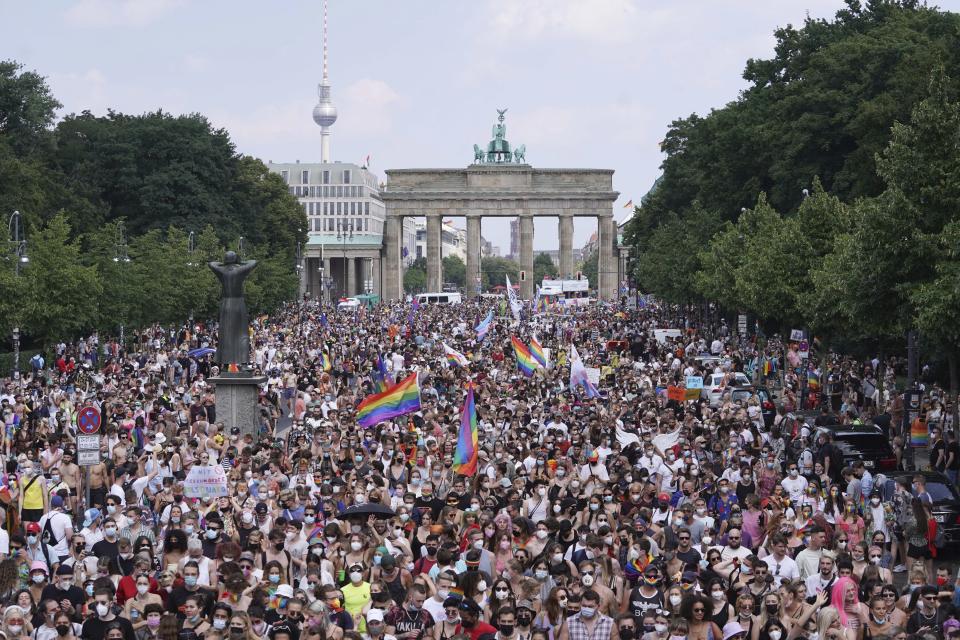 Thousands of people take part in the Christopher Street Day (CSD) parade, with the Brandenburg Gate in the background in Berlin, Germany, Saturday July 24, 2021. (Jorg Carstensen/dpa via AP)