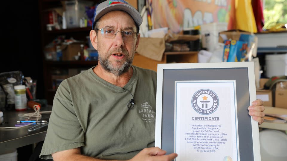 Ed Currie holds up certification that his new Pepper X variety of peppers is the hottest in the world, according to the Guinness Book of World Records - Jeffrey Collins/AP