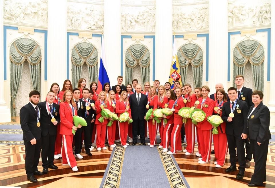 FILE - Russian President Vladimir Putin, center, pose for a photo with athletes during during an awarding ceremony for the Russian Olympic Committee's medalists of the Tokyo 2020 Summer Olympics at the St Catherine Hall in the Kremlin in Moscow, Russia, Saturday, Sept. 11, 2021. (Yevgeny Biyatov, Sputnik, Kremlin Pool Photo via AP, File)