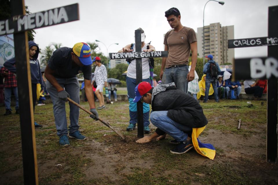 <p>People place crosses, representing people who have died during the most recent opposition protest movement, on the side of a highway during a national sit-in against President Nicolas Maduro, in Caracas, Venezuela, Monday, May 15, 2017. (AP Photo/Ariana Cubillos) </p>