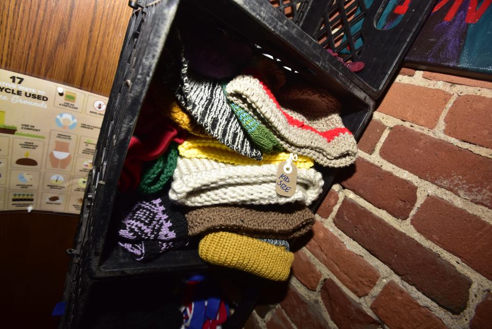 Winter hats and gloves are stacked upon each other as part of the Cozy Crates drive designated to provide free winter clothing for anyone in need at The Raven Cafe at 932 Military St., in downtown Port Huron on Tuesday, Nov. 29. 2022. Brian’s Drive Thru Eggairy and the St. Clair County Library System are also offering free winter clothing in various ways largely donated by the community, to make sure people don’t go cold this winter.