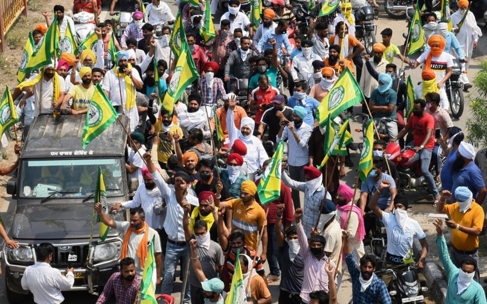 Farmers take part in a protest march against the weekend lockdown imposed by the state government in Amritsar - AFP