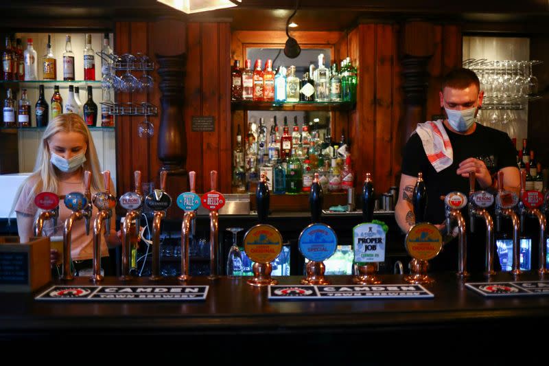 FILE PHOTO: Bartenders pour drinks in a pub in London Bridge amid the outbreak of the coronavirus disease (COVID-19) in London