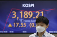 A currency trader walks near a screen showing the Korea Composite Stock Price Index (KOSPI) at the foreign exchange dealing room of the KEB Hana Bank headquarters in Seoul, South Korea, Thursday, April 22, 2021. Asian shares were higher on Thursday after a broad advance on Wall Street led by technology companies and banks. (AP Photo/Lee Jin-man)