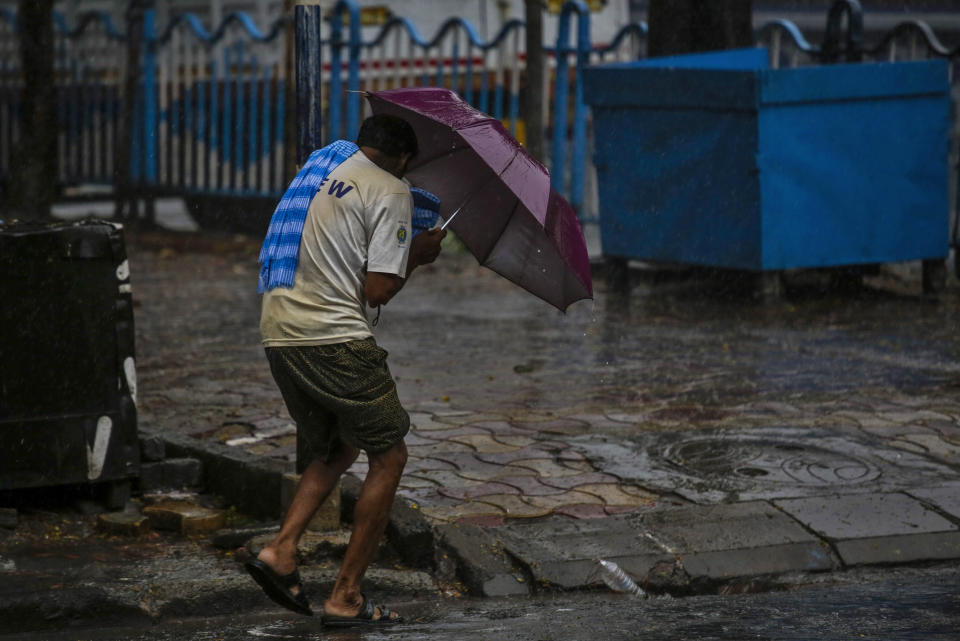 A man struggles to hold his umbrella and walk against high wind in Kolkata, India, Wednesday, May 20, 2020. Amphan, a powerful cyclone has slammed ashore along the coastline of India and Bangladesh where more than 2.6 million people fled to shelters in a frantic evacuation made all the more challenging by the coronavirus pandemic. (AP Photo/Bikas Das)