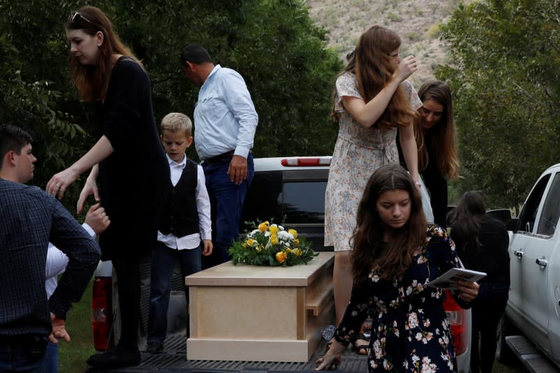 Relatives stand next to one of the coffins of Dawna Ray Langford and her sons Trevor and Rogan, who were killed by unknown assailants, to be buried at the cemetery in La Mora