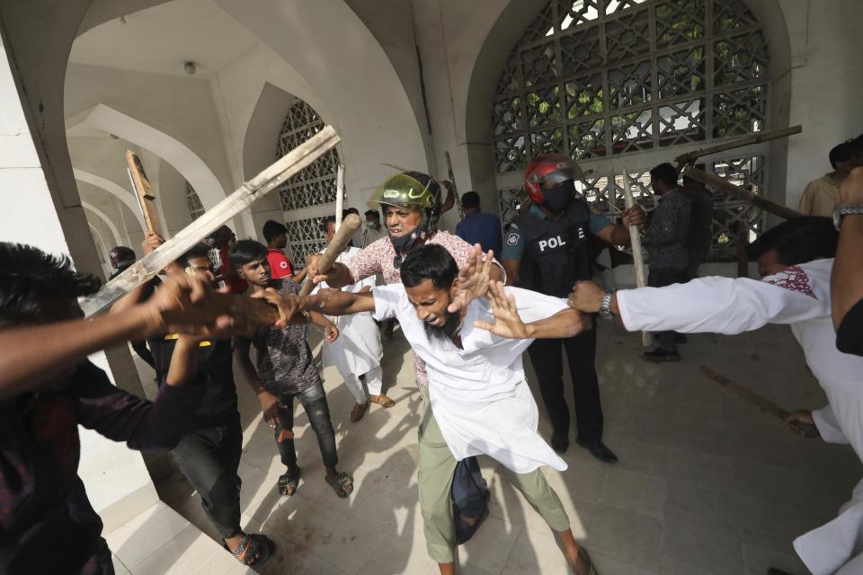 Two factions of protestors clash after Friday prayers at Baitul Mokarram mosque in Dhaka, Bangladesh, Friday, March 26, 2021. Witnesses said violent clashes broke out after one faction of protesters began waving their shoes as a sign of disrespect to Indian Prime Minister Narendra Modi, and another group tried to stop them. Local media said the protesters who tried to stop the shoe-waving are aligned with the ruling Awami League party. The party criticized the other protest faction for attempting to create chaos in the country during Modi’s visit. (AP Photo/Mahmud Hossain Opu)