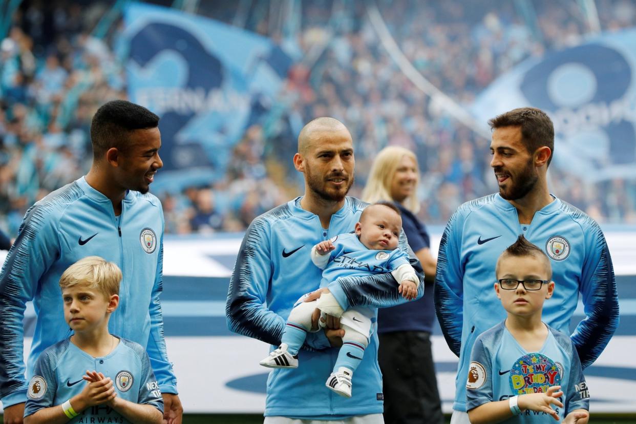 Proud moment: David Silva walked out cradling his son Mateo ahead of the clash with Huddersfield: REUTERS