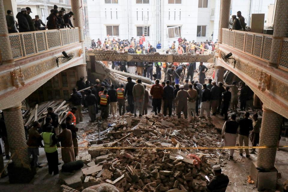 People and rescue workers gather to look for survivors under a collapsed roof, after a suicide blast in a mosque in Peshawar (REUTERS)