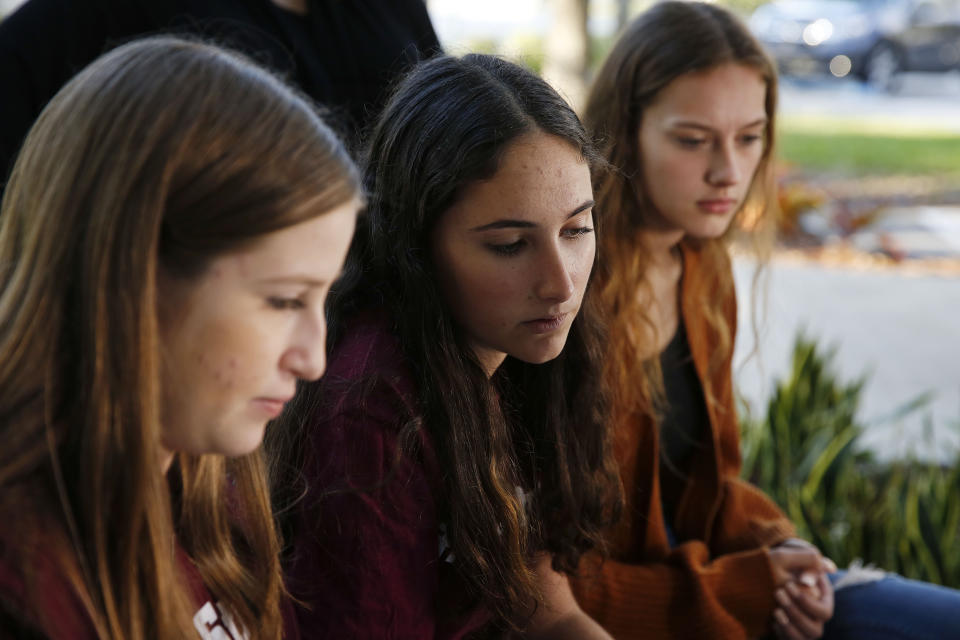 In this Wednesday, Jan. 16, 2019, photo, Brianna Fisher, 16, left, Leni Steinhardt, 16, center, and Brianna Jesionowski sit during an interview with The Associated Press about a new book called "Parkland Speaks: Survivors from Marjory Stoneman Douglas Share Their Stories," in Parkland, Fla. Students and teachers from the Florida school where 17 died in February’s high school massacre wrote the raw, poignant book about living through the tragedy. (AP Photo/Brynn Anderson)