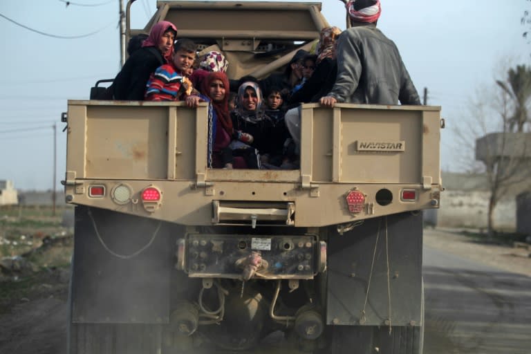 Iraqi families fleeing Mosul's Al-Tayaran neighbourhood sit in the back of a military truck on February 28, 2017, during an offensive by Iraqi forces to retake the area from Islamic State (IS) group fighters