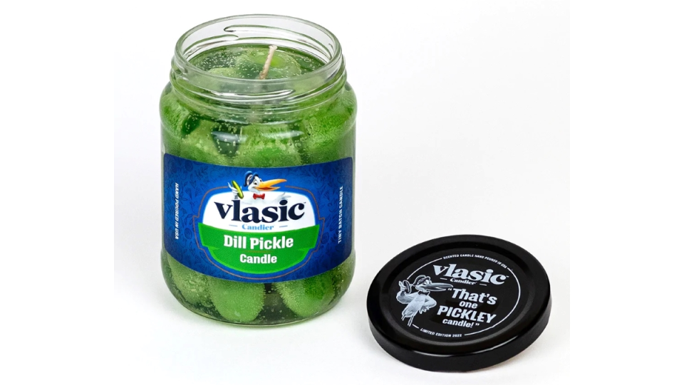 An open glass jar with a candle that looks and smells like Vlasic pickles