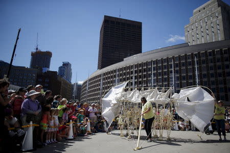 Onlookers watch a display of "Animaris Ordis," one from the series of "Strandbeests" kinetic sculptures by Dutch artist Theo Jansen, at City Hall Plaza in Boston, Massachusetts August 28, 2015. REUTERS/Brian Snyder