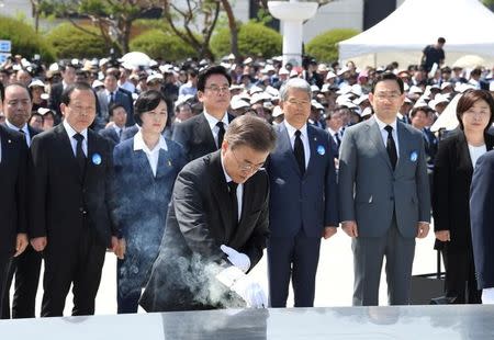 South Korean President Moon Jae-in (C) burns incense during the annual 18 May Democratic Uprising memorial at the Gwangju 18 May National Cemetery in the southwestern city of Gwangju, South Korea, 18 May 2017, as the government holds an annual ceremony to mark the 37th anniversary of a pro-democracy uprising. REUTERS/Kim Min-hee/Pool