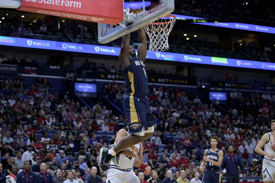 New Orleans Pelicans forward Zion Williamson (1) dunks against Denver Nuggets forward Aaron Gordon (50) in the first half of an NBA basketball game in New Orleans, Sunday, Dec. 4, 2022. (AP Photo/Matthew Hinton)