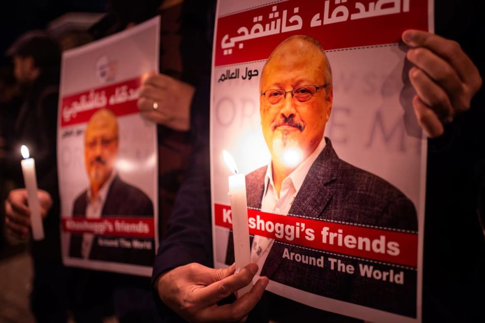 <div class="inline-image__caption"><p>People hold posters picturing slain Saudi journalist Jamal Khashoggi.</p></div> <div class="inline-image__credit"> Yasin Akgul/AFP via Getty</div>