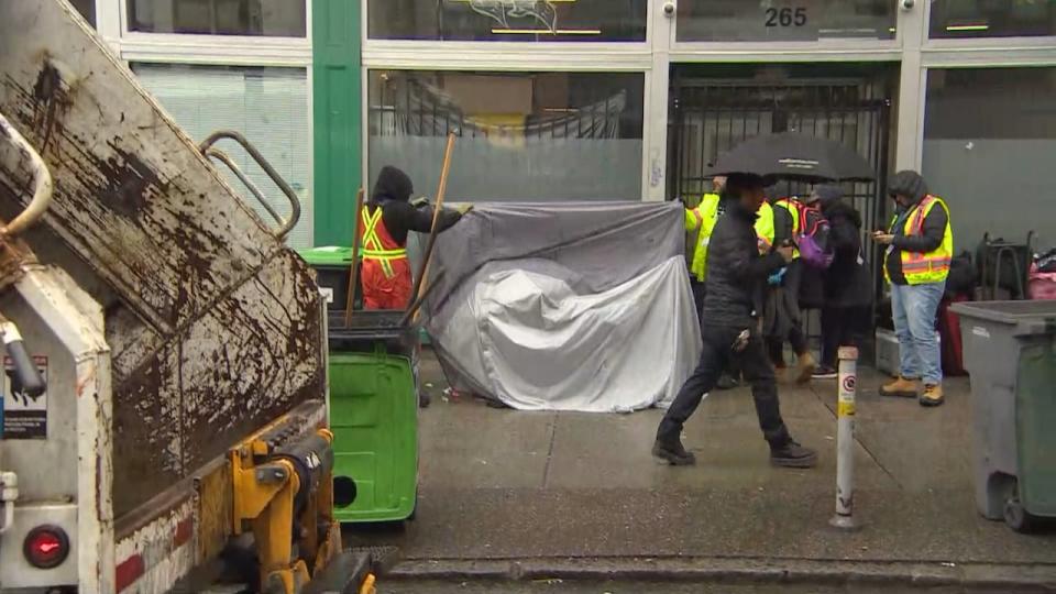 Vancouver city workers are seen removing a tent from East Hastings Street on Thursday April 6, 2023.