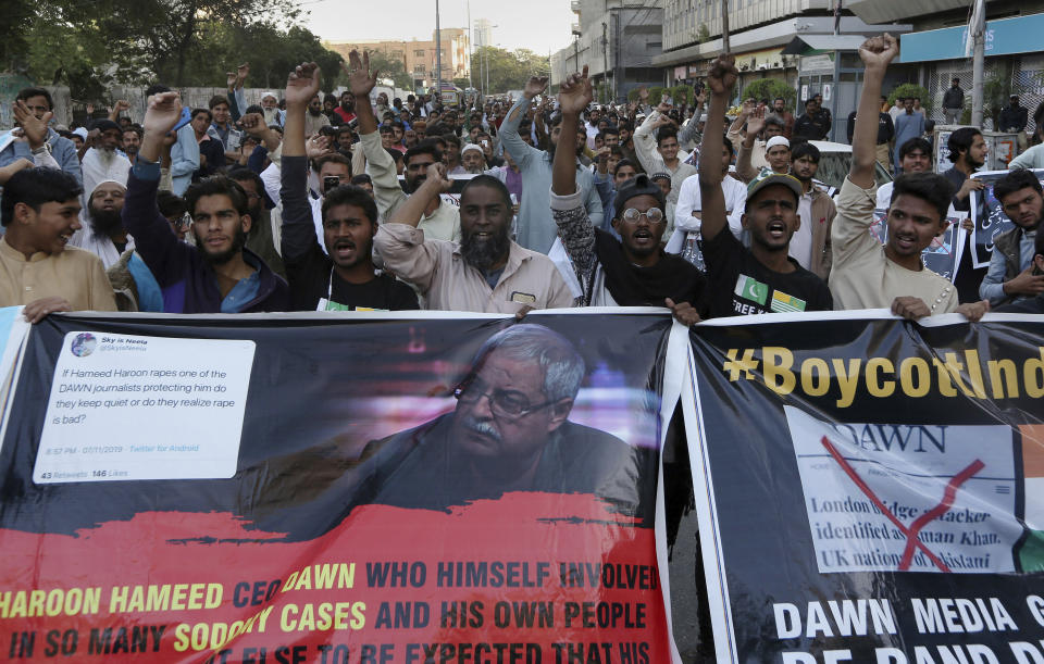 In this Tuesday, Dec. 3, 2019, photo, angry Islamists chant slogans during a demonstration against an independent Pakistani newspaper Dawn, at outside the Press Club in Karachi, Pakistan. Dozens of angry Islamists swarmed the building of an independent Pakistani newspaper in the capital, Islamabad, blocking its entrance for several hours, threatening the staff and demanding its editor be hanged, the newspaper reported Wednesday. (AP Photo/Fareed Khan)