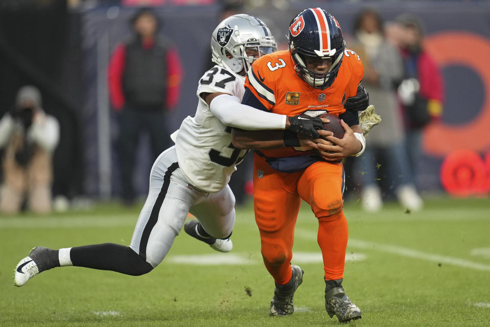 Las Vegas Raiders' Tyler Hall (37) sacks Denver Broncos quarterback Russell Wilson during the second half of an NFL football game in Denver, Sunday, Nov. 20, 2022. (AP Photo/Jack Dempsey)