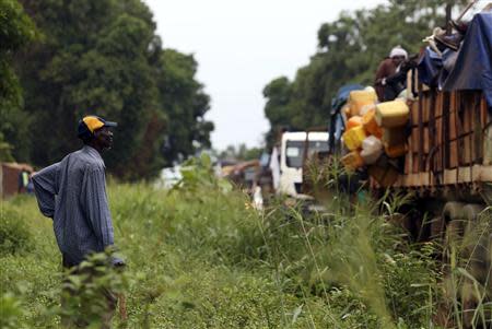 A man watches as Muslims fleeing sectarian violence take a short break on the road between Bangui and Sibut in a convoy being escorted by French peacekeepers to the south eastern town of Bambari April 20, 2014. REUTERS/Emmanuel Braun