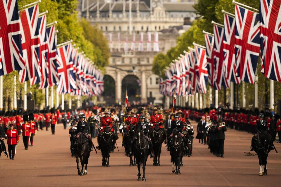 Flags line the way as a procession marches through London.