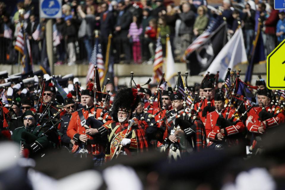 Bagpipers march through a line of firefighters saluting as the funeral procession for Boston firefighter Michael R. Kennedy approaches Holy Name Church in Boston, Thursday, April 3, 2014. Kennedy and Boston Fire Lt. Edward J. Walsh were killed Wednesday, March 26, 2014 when they were trapped in the basement of a burning brownstone during a nine-alarm blaze.(AP Photo/Stephan Savoia)