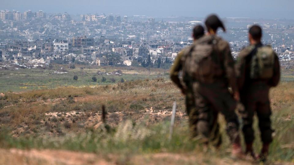 PHOTO: Israeli soldiers look at destroyed buildings in the Gaza Strip as they stand near the Israeli-Gaza border, as seen from southern Israel, Apr. 9, 2024.  (Leo Correa/AP)