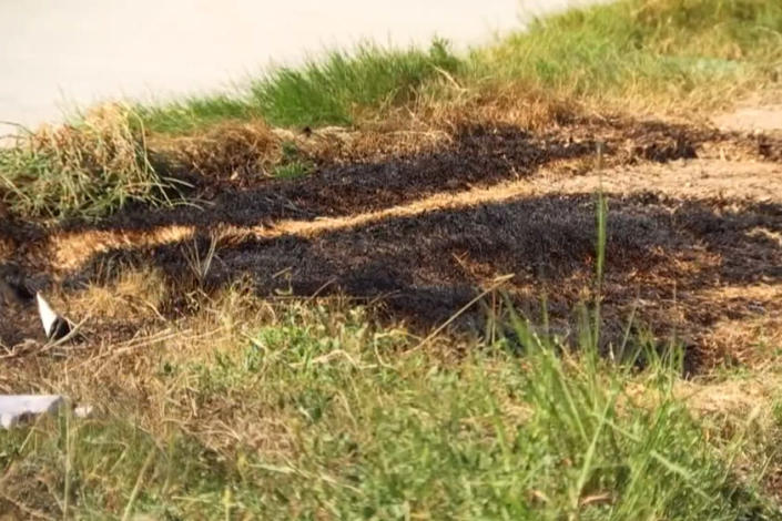 Image: Scarred ground where where three dismembered bodies, including a child, were found in a burning dumpster (not shown) on the city&#39;s west side on Wednesday. (KXAS)