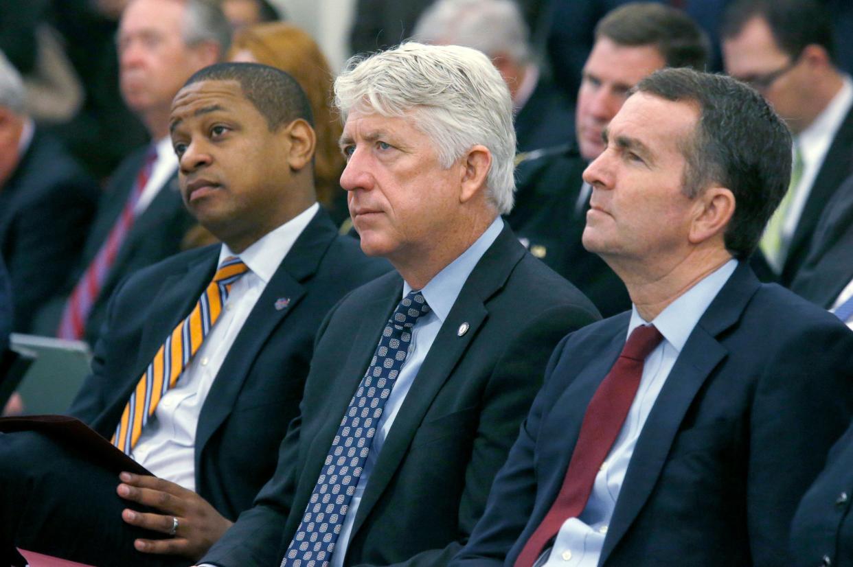 In this Dec. 18, 2017 file photo, from left, Lt. Governor-elect Justin Fairfax, Attorney General-elect Mark Herring and Governor-elect Ralph Northam listen as Virginia Governor Terry McAuliffe addresses a joint meeting of the House and Senate money committees at the Pocahontas Building in Richmond, Va.