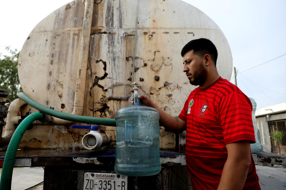 A family man fills a jug of non-potable water in Nuevo Leon during July 2022.  (Gary Coronado/Los Angeles Times via Getty Images)