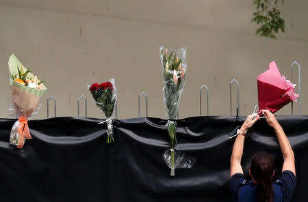 A police officer places flowers outside Masjid Al Noor mosque in Christchurch, New Zealand, March 17, 2019. REUTERS/Jorge Silva