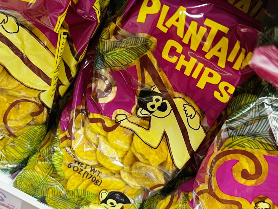 Purple and clear bags of plantain chips with illustrations of monkeys on the packaging