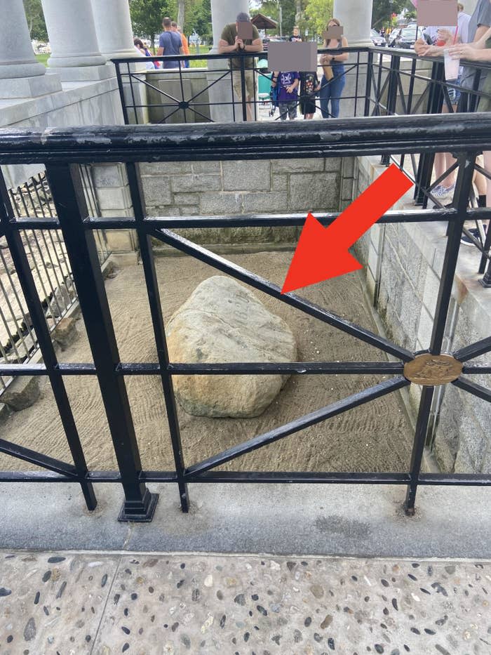 A medium-size rock behind bars