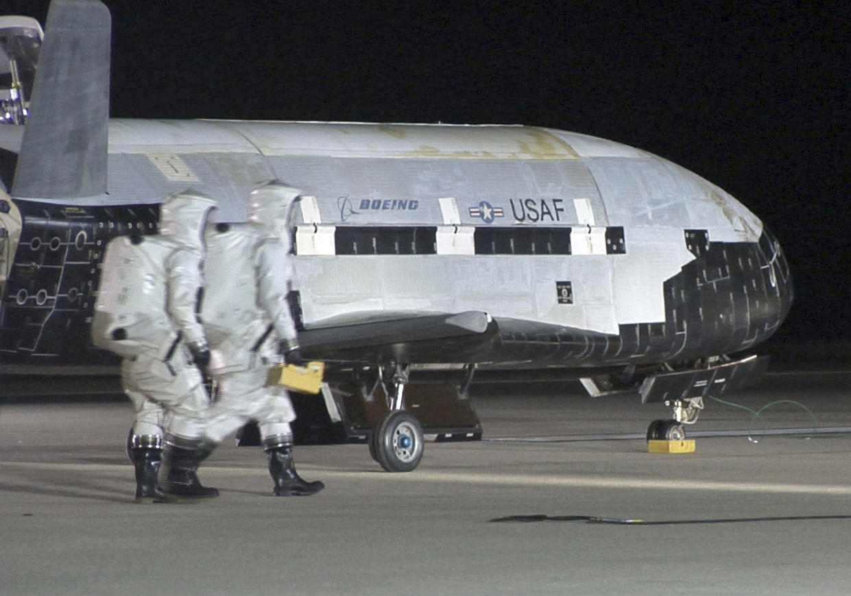 The X-37B Orbital Test Vehicle sits on the runway during post-landing operations Dec. 3, 2010, at Vandenberg Air Force Base, Calif. Technicians in self-contained atmospheric protective ensemble suits conducted initial checks on the vehicle and to ensure the area was safe. (U.S. Air Force photo/Michael Stonecypher) (Photo by DoD/Corbis via Getty Images)