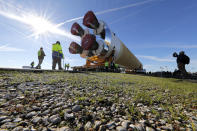 Security and safety personnel walk with the core stage of NASA's Space Launch System rocket, that will be used for the Artemis 1 Mission, as it is moved to the Pegasus barge, at the NASA Michoud Assembly Facility where it was built, in New Orleans, Wednesday, Jan. 8, 2020. It will be transported to NASA's Stennis Space Center in Mississippi for its green run test. (AP Photo/Gerald Herbert)