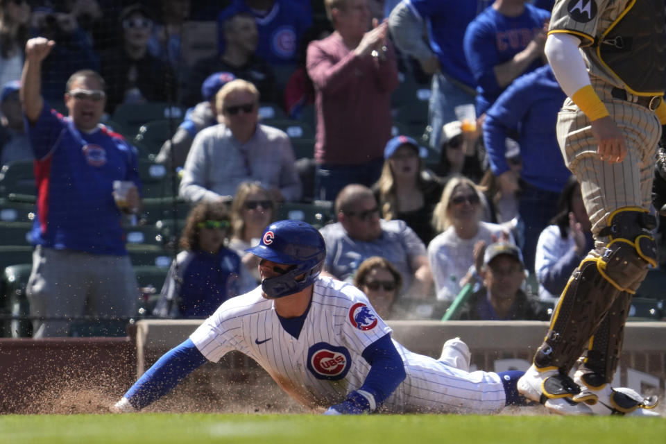 Chicago Cubs' Nico Hoerner, left, scores on a one-run single by Ian Happ during the fifth inning of a baseball game against the San Diego Padres in Chicago, Thursday, April 27, 2023. (AP Photo/Nam Y. Huh)