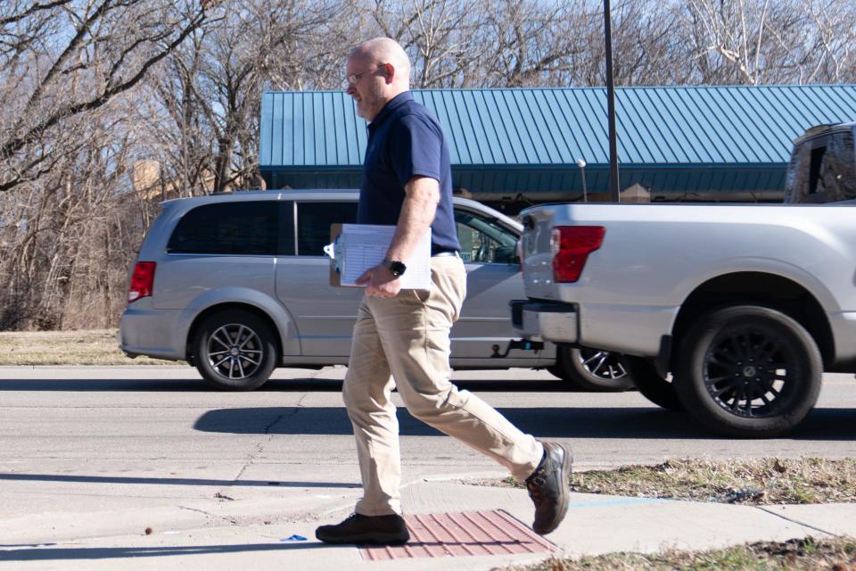 Earl McIntosh walks the sidewalks of S.W. Gage Boulevard on Friday afternoon as he hopes to gather more signatures for his petition asking the city of Topeka to lower property taxes.