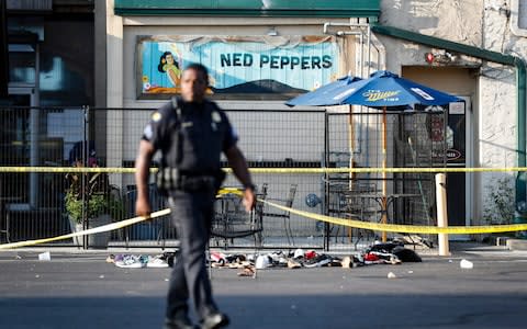 Shoes are piled outside the scene of a mass shooting including Ned Peppers bar - Credit: &nbsp;John Minchillo