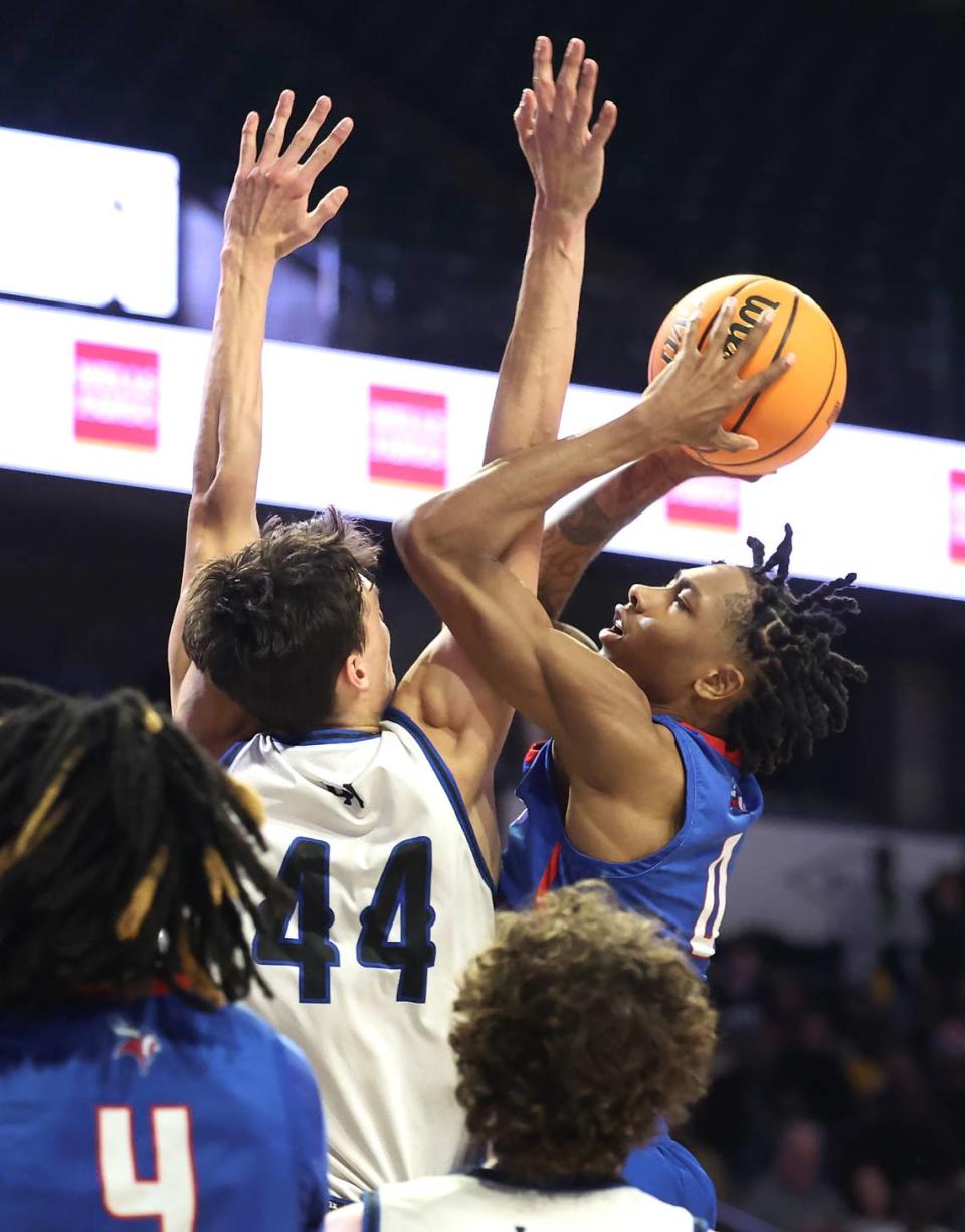 North Meck’s Isaiah Evans, right, drives into the lane for a shot attempt as Lake Norman’s Trent Stelhour, left, applies defensive pressure during the AAAA Regional Championship on Thursday, March 14, 2024 at Lawrence Joel Veterans Memorial Coliseum in Winston-Salem, NC. North Meck defeated Lake Norman 65-61. JEFF SINER/jsiner@charlotteobserver.com