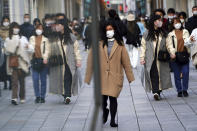 People wearing protective masks to help curb the spread of the coronavirus walk on a street Monday, March 1, 2021, in Tokyo. The Japanese capital confirmed more than 120 new coronavirus cases on Monday. (AP Photo/Eugene Hoshiko)