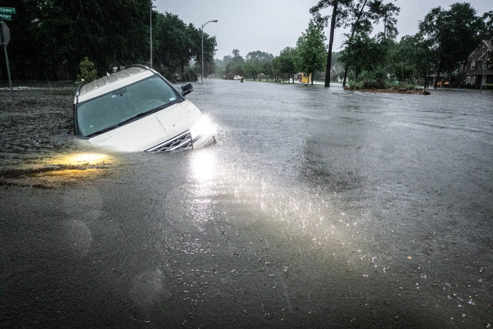 An empty car is caught in high flood waters in the rain (Brett Coomer / Houston Chronicle via Getty Images)