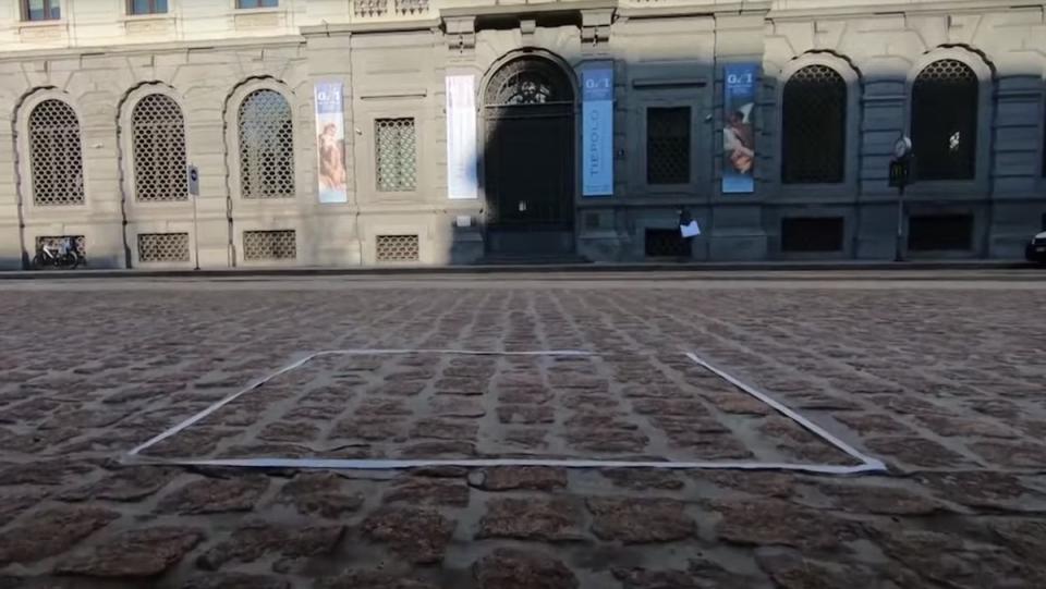 A white square on cobblestone in front of a building during the day