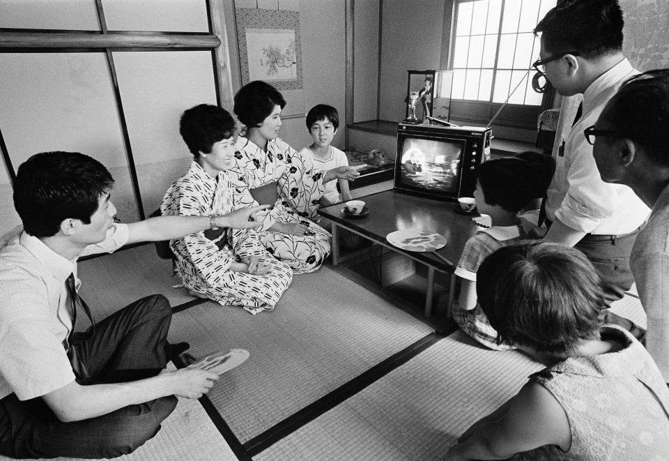 FILE - In this July 21, 1969 file photo, a family in Tokyo watches TV showing U.S. President Richard Nixon superimposed on a live broadcast of the Apollo 11 astronauts saluting from the moon. (AP Photo)