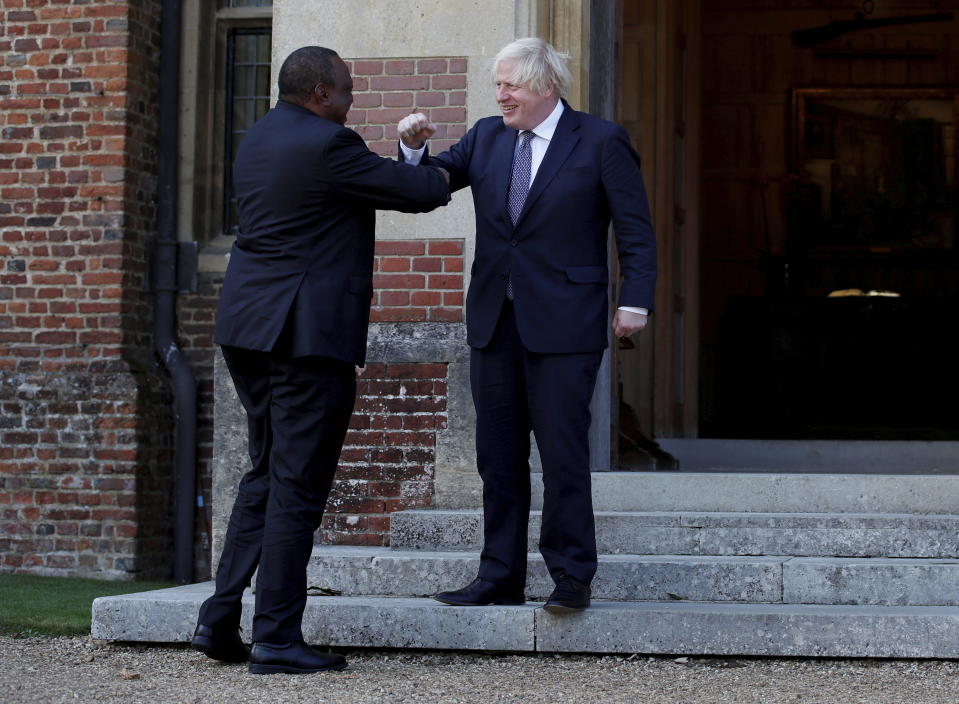 FILE - In this July 28, 2021 file photo, Britain's Prime Minister Boris Johnson greets Kenya's President Uhuru Kenyatta, left, at Chequers, the official country residence of the British Prime Minister, near Aylesbury, England. As workers return to the office, friends reunite and more church services shift from Zoom to in person, this exact question is befuddling growing numbers of people: to shake or not to shake. (Peter Cziborra/Pool via AP, File)