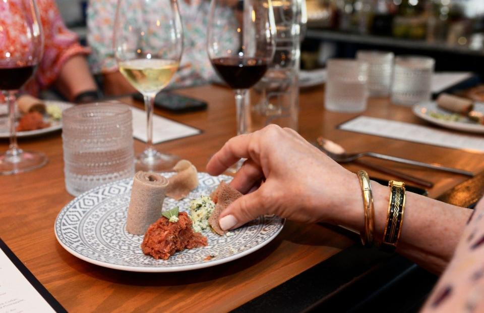 A diner enjoys a traditional Ethiopian kitfo dish prepared by Queen of Sheeba chef/owner Lojo Washington, one of the five James Beard Award semifinalist chefs to prepare a special lunch at Stage Kitchen in Palm Beach Gardens.