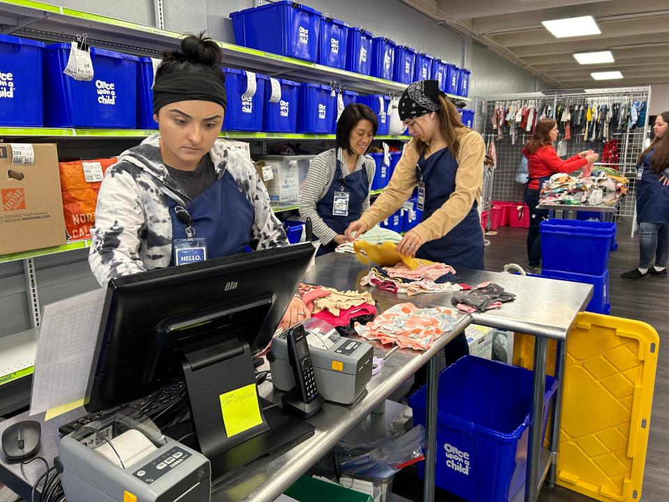 Ariel Ramey, left, co-owner Emily Marr and Karly Estes sort clothes on a weekday inside new Once Upon A Child location on Athens Avenue in Redding.