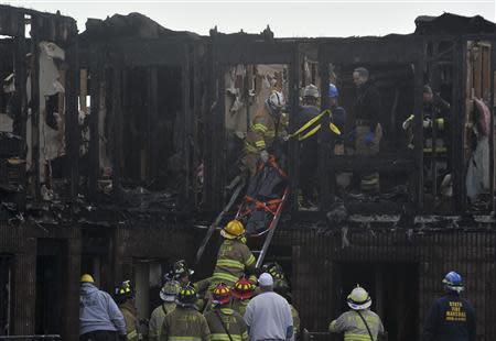 Rescue workers remove a body found in the charred remains of the Mariner's Cove Inn in Point Pleasant Beach, New Jersey, March 21, 2014. REUTERS/Charles Mostoller