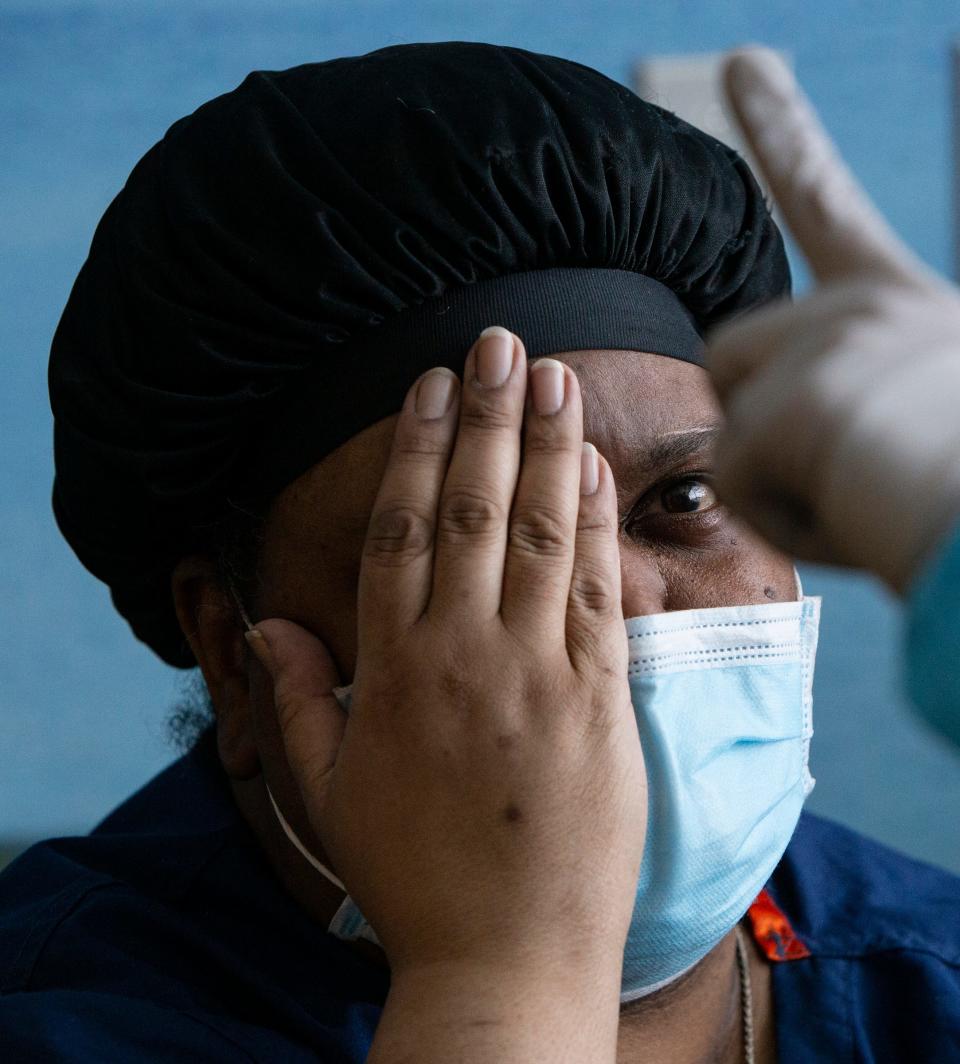 Charlunda Thompson, 45, of Inkster, left, has her eyes checked by Kate Aeschlimann, an occupational therapist at Mary Free Bed Rehabilitation Hospital in Grand Rapids, as she recovers from COVID-19.