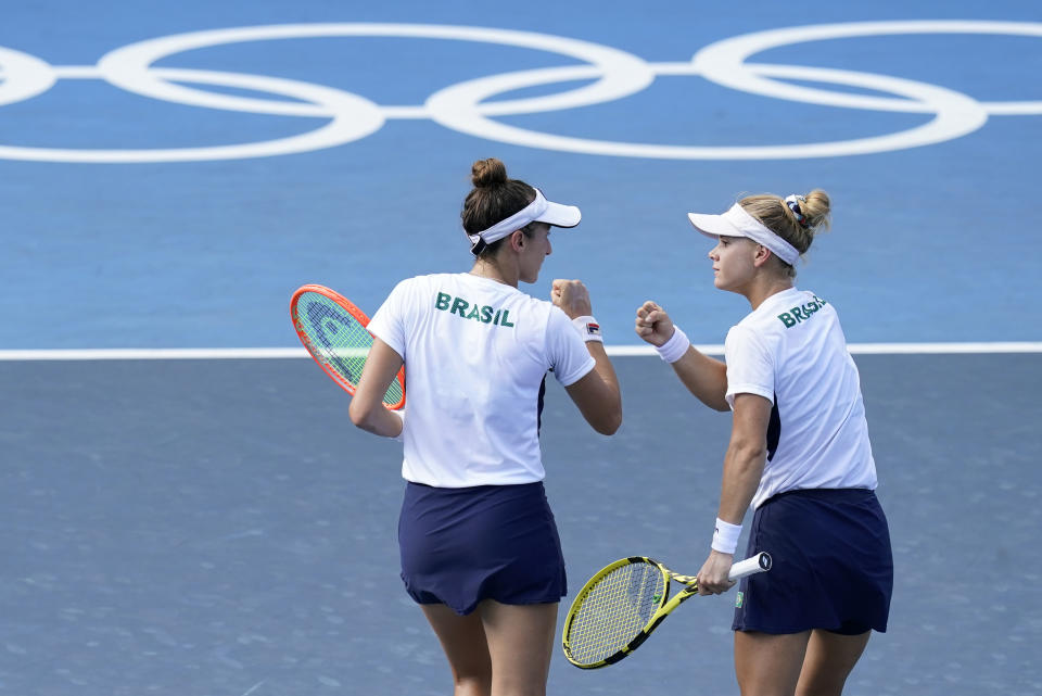 Luisa Stefani, left, and Laura Pigossi, of Brazil, speak during the women's doubles bronze medal tennis match against Veronika Kudermetova and Elena Vesnina, of the Russian Olympic Committee, at the 2020 Summer Olympics, Saturday, July 31, 2021, in Tokyo, Japan. (AP Photo/Patrick Semansky)